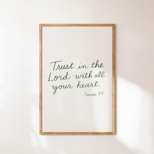 May include: A framed print with the text "Trust in the Lord with all your heart. - Proverbs 3:5" in green script on a white background. The frame is a light brown color.