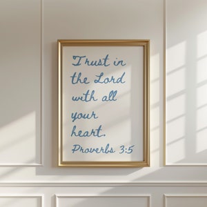 Könnte beinhalten: Ein gerahmter Druck mit einem goldenen Rahmen und weißem Hintergrund. Der Text auf dem Druck lautet "Trust in the Lord with all your heart. Proverbs 3:5".