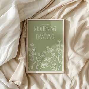 May include: A framed print with a green background and white floral design. The text "You turn mourning to dancing" is written in white.