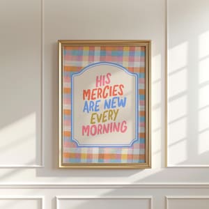 Könnte beinhalten: Gerahmter Kunstdruck mit dem Text "HIS MERCIES ARE NEW EVERY MORNING" in bunten Buchstaben. Das Kunstwerk zeigt einen karierten Hintergrund in Orange-, Blau- und Rosatönen und ist in einem goldenen Rahmen eingefasst.
