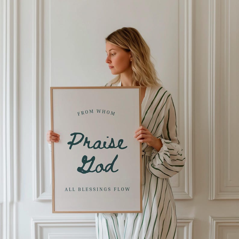 May include: A white framed poster with the text "From Whom Praise God All Blessings Flow" in black and teal lettering.