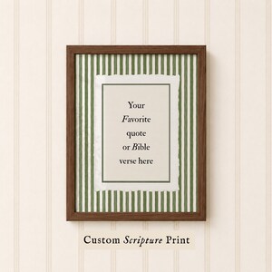 Puede incluir: Una impresión enmarcada con un marco de madera marrón oscuro. La impresión presenta un fondo blanco con el texto "Your Favorite quote or Bible verse here" en fuente negra. El fondo detrás de la impresión blanca es de rayas verdes y blancas. Las palabras "Custom Scripture Print" están en la parte inferior.