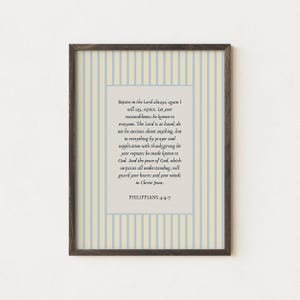 Könnte beinhalten: Gerahmter Druck mit Text aus Philipper 4:4-7. Der Text befindet sich auf einem cremefarbenen Hintergrund, umgeben von einem hellblau-cremefarbenen Streifenmuster. Der Rahmen ist dunkelbraun. Geeignet für die Inneneinrichtung.