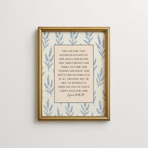 May include: A framed print with a gold-colored frame. The print features a cream-colored background with a repeating pattern of blue floral sprigs. The center of the print contains text from Romans 8:38-39.