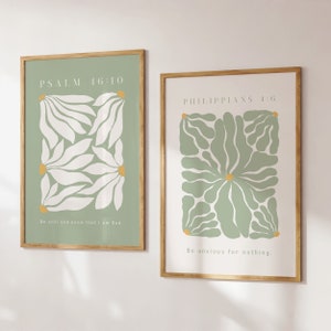 May include: Two framed prints with green and white floral designs and inspirational quotes. The top print reads "PSALM 16:10 Be still and know that I am God." The bottom print reads "PHILIPPIANS 4:6 Be anxious for nothing."