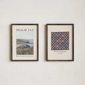 May include: Two framed prints with dark brown wooden frames. One print features a landscape with text "PSALM 33:2" and "Blessed is the nation whose God is the Lord." The other print has a quilt pattern with text "You hem me in behind, and before" and "PSALM 139:5."