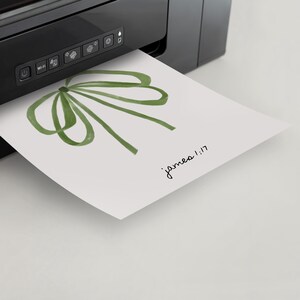 May include: A green watercolor bow with the text "james 1:17" printed below it. The bow is being printed from a black printer.