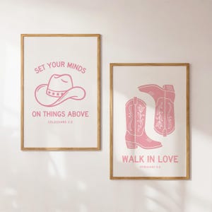 May include: Two framed prints with pink designs on a white background. One features a cowboy hat and the text "SET YOUR MINDS ON THINGS ABOVE." The other shows cowboy boots with the text "WALK IN LOVE."