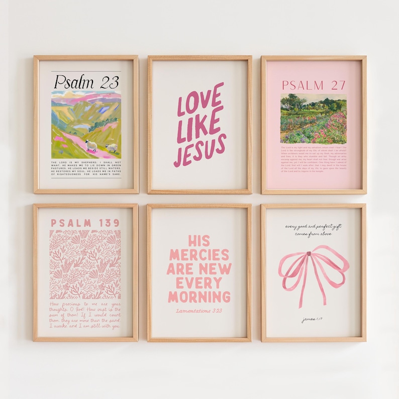 May include: Six framed prints with pink and white designs and text. The prints feature bible verses and inspirational quotes. The prints are arranged in a grid pattern on a white wall.