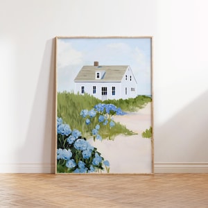 May include: A framed art print of a white house with a gray roof, nestled among green grass and blue flowers. A sandy path leads to the house, with a light blue sky in the background. The artwork is in a wooden frame.