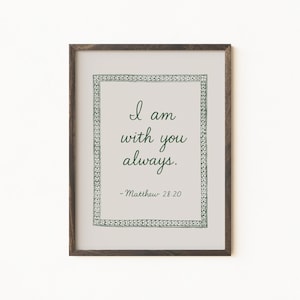 Puede incluir: Impresión enmarcada con el texto "I am with you always" en una fuente de escritura. El texto es de color verde oscuro, rodeado por un borde decorativo, sobre un fondo claro. El marco es de color marrón oscuro.