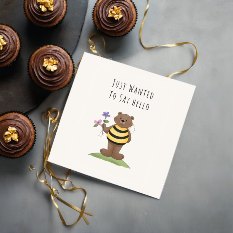 Displayed on a table next to delicious chocolate cupcakes, the 'Just Wanted To Say Hello' Card adds a sweet and cheerful touch to the moment