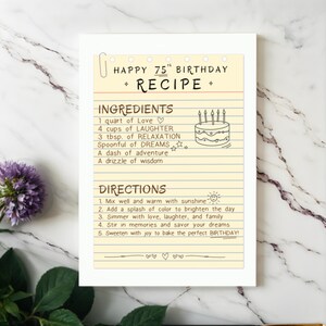 Celebrate their 75th birthday with a one of a kind 75th recipe Birthday Card that is a recipe for life, mixing love, adventure, and dreams. The original birthday card is shown next to elegant flowers on a granite countertop.