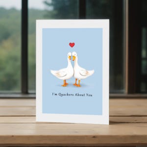 This picture displays the 'I'm Quackers About You' Anniversary Card in front of a window with trees in the background, showcasing a charming view.