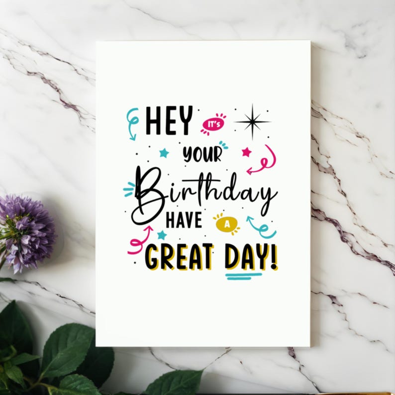 Showcased on a white granite countertop next to vibrant purple flowers, the Birthday Card adds a touch of charm and joy to any celebration.