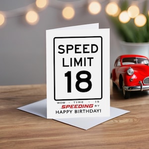 Celebrate their 18th birthday with our Speed Limit Birthday Card, beautifully displayed alongside a classic red model car.