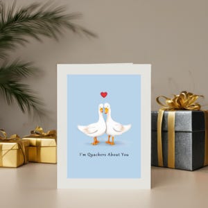 Set in front of colorful presents, the 'I'm Quackers About You' Anniversary Card adds a delightful and festive touch to the celebration