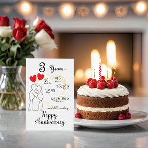 Celebrate your 3 year anniversary with an enchanting card featuring a gold heart, intertwined heart balloons held by stick figures, and an anniversary cake for timeless elegance.