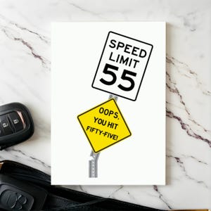 Celebrate their 55th birthday with a humorous 'Oops You Hit 55' Birthday Card, shown next to a pair of car keys. This thoughtful combination adds a memorable touch to their special day, symbolizing the beginning of an exciting journey ahead.