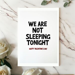 Funny Valentine card displayed on a white surface. The minimalist design highlights the bold text We are not sleeping tonight with a red Happy Valentines Day line.