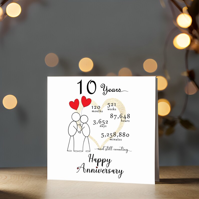 Celebrate your 10 year anniversary with an enchanting card. It features a gold heart and intertwined heart balloons held by stick figures. This screen shot shows presents the 5" x 5" card.
