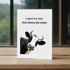 This picture shows the 'Moo-velous Birthday' Card in front of a window with trees in the background, highlighting a charming view.