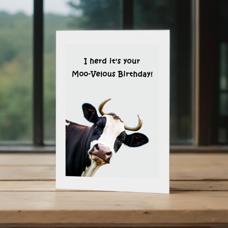 This picture shows the 'Moo-velous Birthday' Card in front of a window with trees in the background, highlighting a charming view.