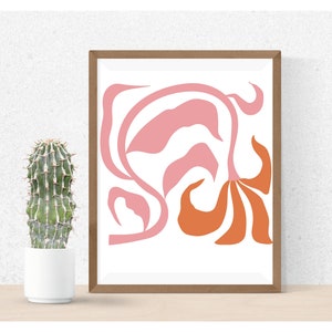 May include: Abstract art print with a pink and orange floral design in a brown frame. The print is on white paper.