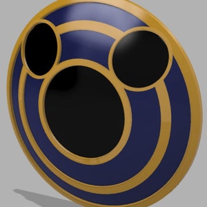 May include: A circular, navy blue and gold-colored decorative object with three black circular cutouts. The object has a gold border and two gold concentric circles. The object is set against a gray background.