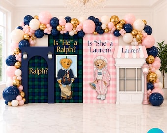 May include: A gender reveal party backdrop set featuring a balloon arch in navy blue, light pink, and gold. The display includes two panels with teddy bear illustrations, text reading Is He a Ralph? and Is She a Lauren?, and a white shop facade.