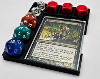 May include: A black plastic tray with a card game piece and six dice. The card is a Magic: The Gathering card called "Marrow-Gnawer". The dice are various colors, including red, blue, green, and white.