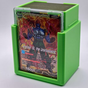 May include: A green card deck box with a clear plastic insert to display a trading card featuring a red and blue character with the text "Android 13, the Unstoppable" and "15000".