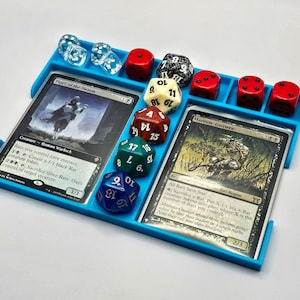 May include: A blue plastic game tray with two Magic: The Gathering cards, "Piper of the Swarm" and "Marrow-Gnawer", and several dice. The dice are black, white, red, and green.