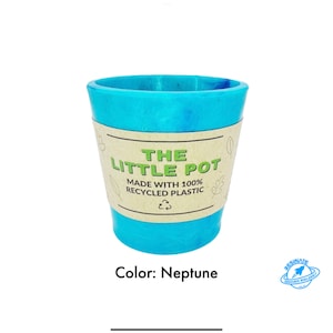 Könnte beinhalten: Ein türkisblauer, recycelter Plastiktopf mit einem braunen Etikett, auf dem "The Little Pot Made with 100% Recycled Plastic" steht. Das Etikett hat ein grünes Recycling-Symbol. Der Topf heißt "Neptune".