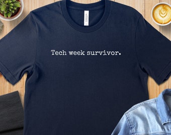 May include: A navy blue t-shirt with the text "Tech week survivor." printed in white.