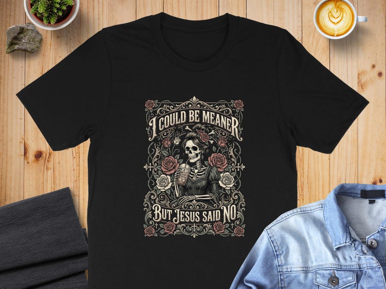 Black t-shirt with a skeleton wearing a crown of roses, text reads "I COULD BE MEANER BUT JESUS SAID NO".