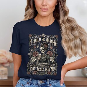 T-shirt with skeleton, roses, and text "I COULD BE MEANER BUT JESUS SAID NO".