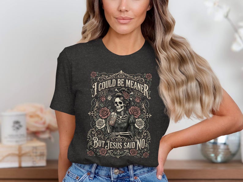 Dark t-shirt with skeleton, roses, and text "I COULD BE MEANER BUT JESUS SAID NO".