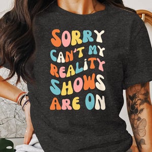 Groovy Sorry cant my reality shows are on fun colorful graphic tee gift for tv show lovers trendy casual t-shirt for men and women