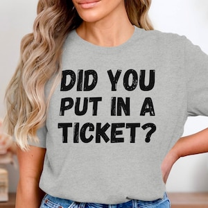 May include: Gray t-shirt with black text that reads "Did you put in a ticket?"