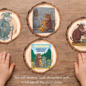 May include: Four circular wood slices featuring colourful illustrations of characters from the Gruffalo story. One slice displays the text Gruffalo Granny above a forest scene with three characters. The slices are arranged on a wooden surface.