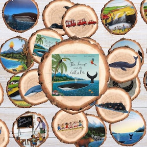 Puede incluir: Una colección de adornos de rodajas de madera con ilustraciones del libro infantil "The Snail and the Whale". Los adornos representan ballenas, paisajes y escenas de la historia, con la portada del libro en el centro.