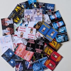 May include: A collection of paperback books by Freida McFadden, featuring titles like "The Housemaid," "Surrogate Mother," and "The Wife Upstairs." The book covers display various colors and designs, with text visible on each cover.