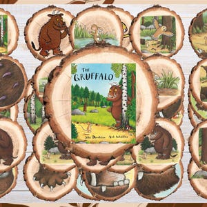 Könnte beinhalten: Eine Sammlung runder Holzscheiben mit gedruckten Illustrationen aus dem Buch Der Grüffelo. Jedes Stück zeigt Szenen mit dem braunen Monster, einer Maus und Waldelementen. Die mittlere Scheibe zeigt das Buchcover mit dem Titel Der Grüffelo.
