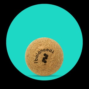 May include: A brown cork massage ball with the text "the balanced" printed on it.
