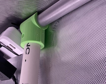 May include: A green plastic pipe clamp attached to a silver metal pipe. The pipe is labeled with a barcode and the text "JC".