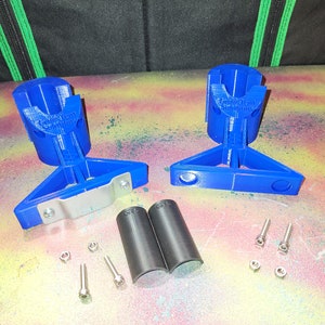 May include: Two blue 3D printed bike rack mounts with silver metal brackets, two black rubber bike rack sleeves, and silver screws and nuts.