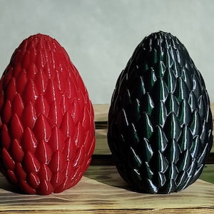 Puede incluir: Cuatro objetos decorativos con forma de huevo de dragón con textura escamosa. Los huevos son morado, rojo, negro y azul.