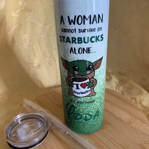 以下が含まれることがあります： 緑色のグリッターデザインと「A WOMAN cannot survive on STARBUCKS ALONE... She also needs YODA」の文字が入った白いタンブラー。スターバックスのカップを持ったベビーヨーダの漫画の画像が特徴です。透明な蓋とストローが含まれています。