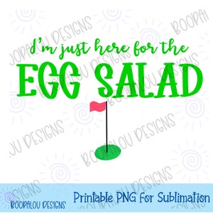 May include: Green text on a white background reads "I'm just here for the egg salad". A green golf green with a red flag is below the text.